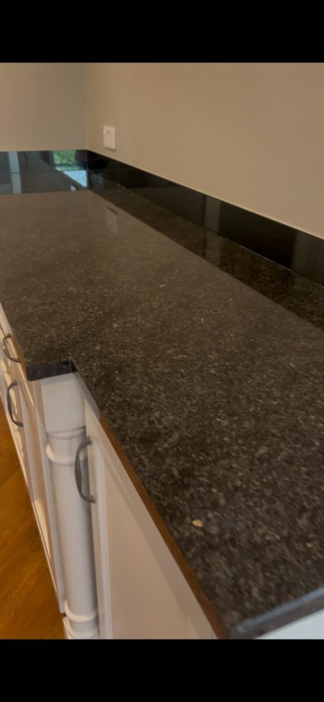 Close view along a restored granite worktop showing an even polished edge and upstand